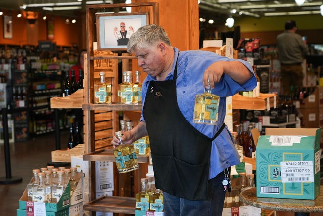 Robert Hernandez Jr. stocks Santo tequila before the Guy Fieri meet-and-greet at Twins Liquor at the Hancock Center on Thursday, March 28, 2024. Fieri came to Texas in support of his and Sammy Hagar’s Santo Spirits brand.